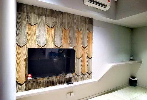 a flat screen tv on a wall in a room at Seaview Cozy BS Homestay in Kota Kinabalu