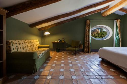 a bedroom with a bed and a couch and a window at Relais Regina Giovanna in Sorrento