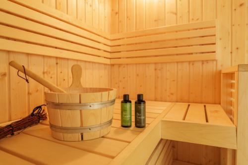 a wooden sauna with two bottles and a bucket at Altes Forsthaus - Fewo "Wiesental", privater "Spa" mit Sauna, Wanne und Relaxliegen, Todtnau- Feldberg in Todtnau