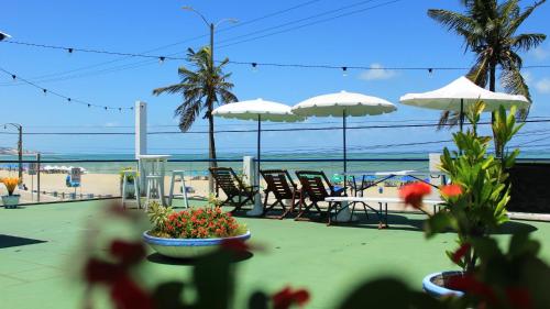 a view of a beach with chairs and umbrellas at Ponta Negra Suites & Apart in Natal