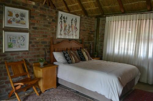 a bedroom with a bed and a brick wall at Kudusdrift Farmstay in Vaalwater