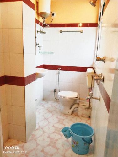y baño con aseo, lavamanos y cubo. en Sunrise Homestay & Lodge, en Guwahati
