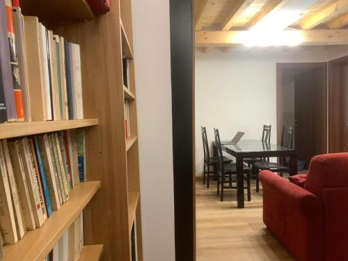 a living room with a table and a red couch and books at Centrocitta' in Carpi