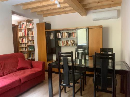 a living room with a red couch and a glass table at Centrocitta' in Carpi