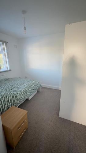 ein Schlafzimmer mit einem Bett, einer Schublade und einem Fenster in der Unterkunft Bling Paradise in Potters Bar