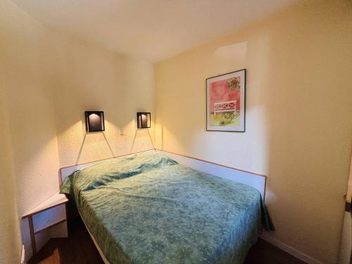 a small bedroom with a bed and two lights on the wall at Appt cosy 5 pers à La Plagne, proche pistes, animaux admis - FR-1-353-57 in La Plagne