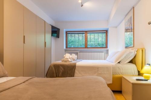 a bedroom with two beds and a window at MCX Vacation Rental- Cervino Lodge in Breuil-Cervinia