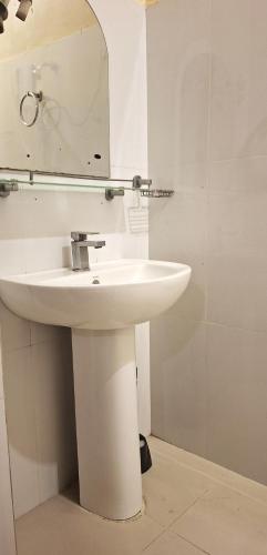 a bathroom with a white sink and a mirror at New Colombo Village in Kalapaluwawa