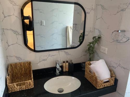 une salle de bain avec un lavabo et un miroir dans l'établissement Apus Paradise House Valle Sagrado, à Urubamba