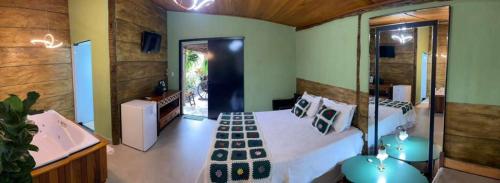 a bedroom with a bed and a bath tub and a sink at Pousada Nascente do São Francisco in Vargem Bonita