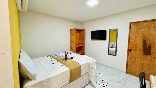 a bedroom with a bed and a tv and a door at Porto Dolce Vita in Porto De Galinhas