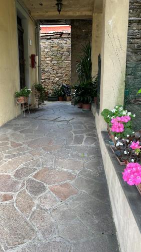 a walkway with flowers and plants in a building at La Casa della Nonna in stile antico in Castel del Rio