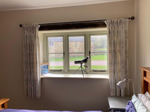 a window in a bedroom with a camera on the sill at Peace & Tranquillity - Breathe Nature & Star Gaze in Eaton