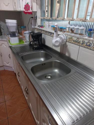a kitchen with a stainless steel sink in a kitchen at Casa Azul da Marina in Três Coroas