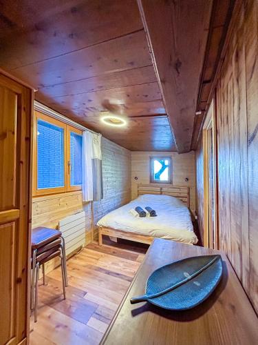 a room with a bed and a table with a surfboard on it at Charmant Appartement Alpin in Oberems