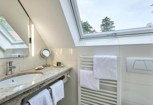 a bathroom with a sink and a window at Hotel Alpenhof - ruhige Wohlfühloase zwischen München, dem Fünf-Seenland und den Bergen, in S-Bahnnähe in Gauting