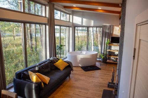 LādezersにあるBrīvdienu māja Empagiのリビングルーム(ソファ、バスタブ付)