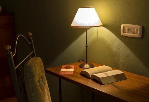 a lamp sitting on a desk with a book and a book at Relais Regina Giovanna in Sorrento