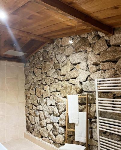 a stone wall in a bathroom with towels at Bergerie du Prunelli in Cauro