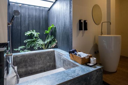 uma casa de banho com uma grande banheira com uma planta em The Arch Casa - Design Hotel Pai em Pai