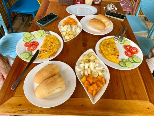 a wooden table with plates of food on it at Tam Coc My Tho Homestay in Vũ Lâm