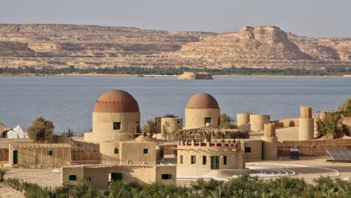 a village in the middle of the desert with a body of water at Marcelia Eco-Village Front Lake View in Siwa