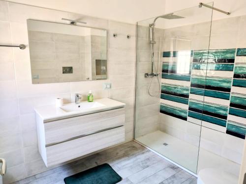 ein Badezimmer mit Waschbecken und Dusche in der Unterkunft Chill out Home Fregene Family Group Accomodation - 15 minuti da Fiumicino - Casa Vacanza Fregene vicino al mare in Fregene