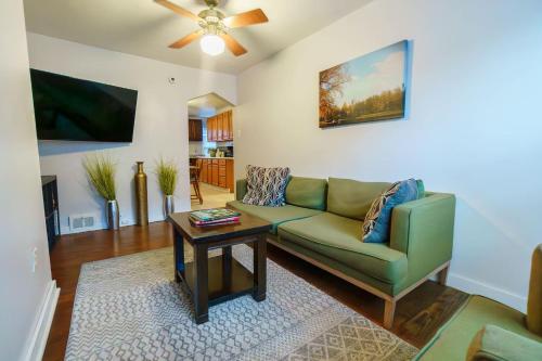 a living room with a green couch and a table at 3 BR Southside Pad - Sleeps 8 - Amazing Location in Pittsburgh