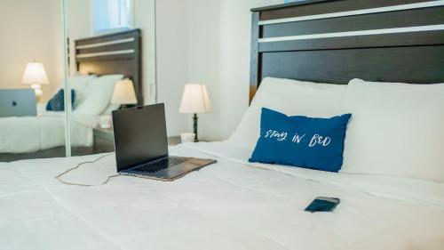 a laptop computer sitting on a bed with a blue pillow at 3 BR Southside Pad - Sleeps 8 - Amazing Location in Pittsburgh