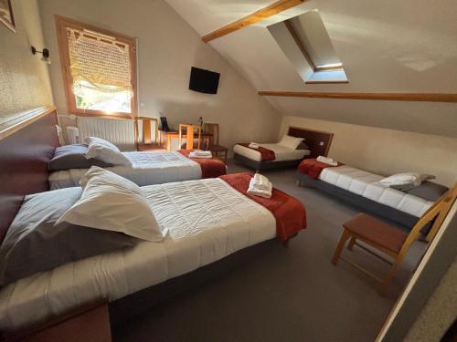 a room with four beds and a window at Les Hirondelles in Orcines