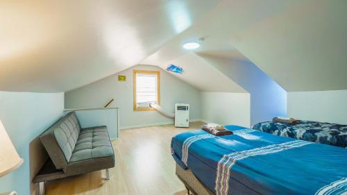 a attic bedroom with a bed and a chair at 3 BR Southside Pad - Sleeps 8 - Amazing Location in Pittsburgh