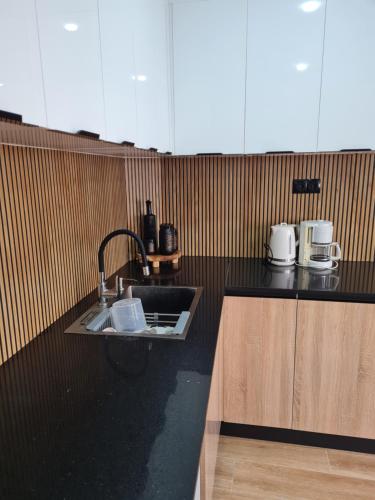 a kitchen with a sink and a black counter top at Modern luxury apartment -f4- central Sétif in Sétif