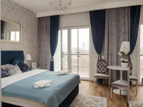 a bedroom with a bed and a table and a window at Prymasa Tysiąclecia 83A City Center View By Perfect Apart in Warsaw