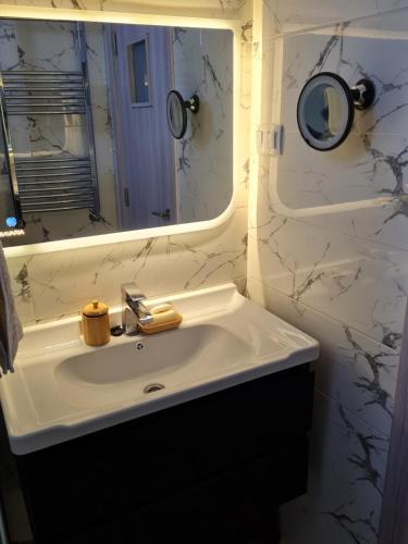 a bathroom with a white sink and a mirror at Modern luxury apartment -f4- central Sétif in Sétif