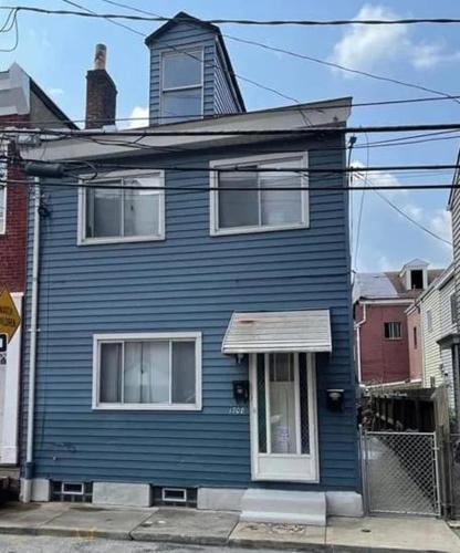 a blue house sitting on a city street at 3 BR Southside Pad - Sleeps 8 - Amazing Location in Pittsburgh