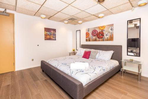 a bedroom with a bed and a television in it at King Bed Studio Apartment - Near Chinatown in Ottawa