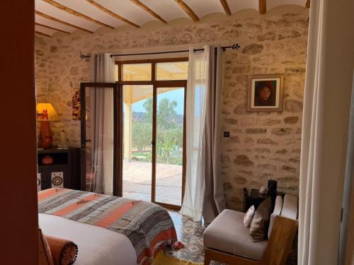 エッサウィラにあるVilla des Hauts Mogadorのベッドとガラスの引き戸のある寝室