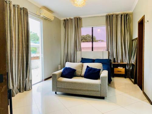 Una sala de estar con un sofá y una ventana grande. en COP30 ALTO PADRÃO Belém Brasil, en Belém