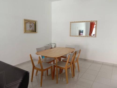 a dining room table with chairs and a mirror at The Diana Residence Muar in Muar