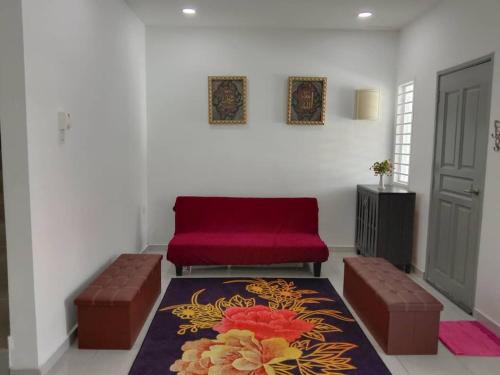 a living room with two stools and a red couch at The Diana Residence Muar in Muar