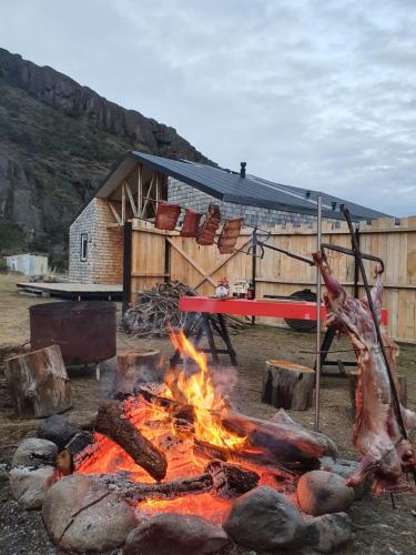 a camp fire in front of a barn at Refugio Cerro Castillo in Villa Cerro Castillo