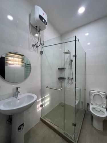 a bathroom with a shower and a sink and a toilet at Nouveau Apartment in Abuja