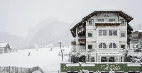 a large building in the snow in front of a ski lodge at Alpstay - Hotel Acadia - Adults Mountain Home in Selva di Val Gardena