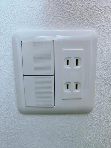 a white light switch on a wall at Moon Hotel in Tokyo