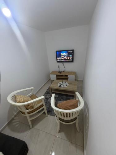 a room with two chairs and a table and a television at יחידת דיור חדשה עם מקלט - היחידה בגליל in Qiryat Shemona