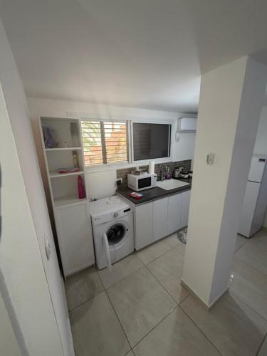 a small kitchen with a washer and dryer at יחידת דיור חדשה עם מקלט - היחידה בגליל in Qiryat Shemona