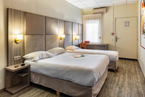 a hotel room with two beds in a room at Le Trèfle in Portet-sur-Garonne