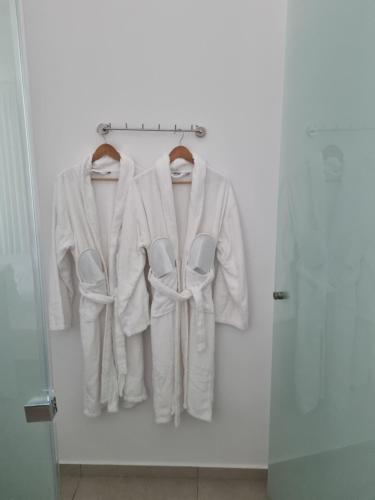 two white robes hanging on a rack in a room at Blue Summer Luxury Suites in Kourouta