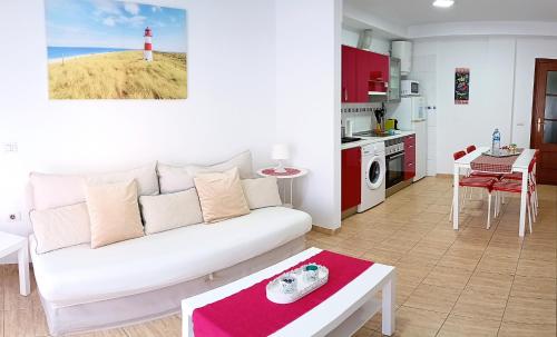 a living room with a white couch and a lighthouse at Appartamento Mochiri - San Isidro in San Isidro