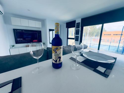 ArguineguínにあるModern Concept, Seaside Apartmentのワイングラス2杯付きのテーブルに座ったワイン1本
